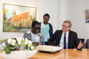 Eine Ehre für besondere Gäste (von links): Solomon Otwao und Caroline Kiyai trugen sich in das Goldene Buch der Gemeinde Wallenhorst ein, das Bürgermeister Otto Steinkamp für sie gern aufschlug. Foto: Gemeinde Wallenhorst / André Thöle