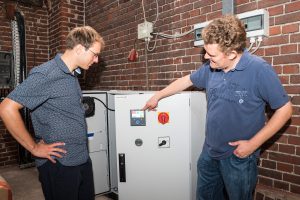 Christian Trame (rechts) erläutert Klimaschutzmanager Stefan Sprenger seine Photovoltaikanlage mit Batteriespeicher, für die er im vergangenen Jahr mit dem Klimaschutzpreis ausgezeichnet wurde. Foto: Gemeinde Wallenhorst / Thomas Remme