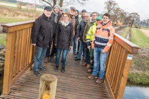 Mitglieder des Arbeitskreises Dorferneuerung, Vertreter der Gemeindeverwaltung und der Baufirmen sowie Bürgermeister Otto Steinkamp (3. von rechts) präsentieren die neue Brücke am Erftenbecksweg. Foto: Thomas Remme