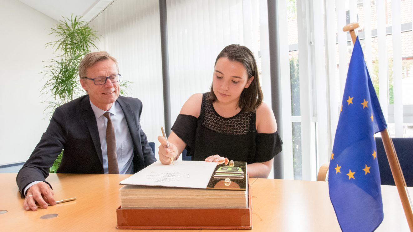 Das Goldene Buch öffnet Bürgermeister Otto Steinkamp für besondere Gäste, so auch für die Schülerinnen und Schüler aus Frankreich. Foto: André Thöle