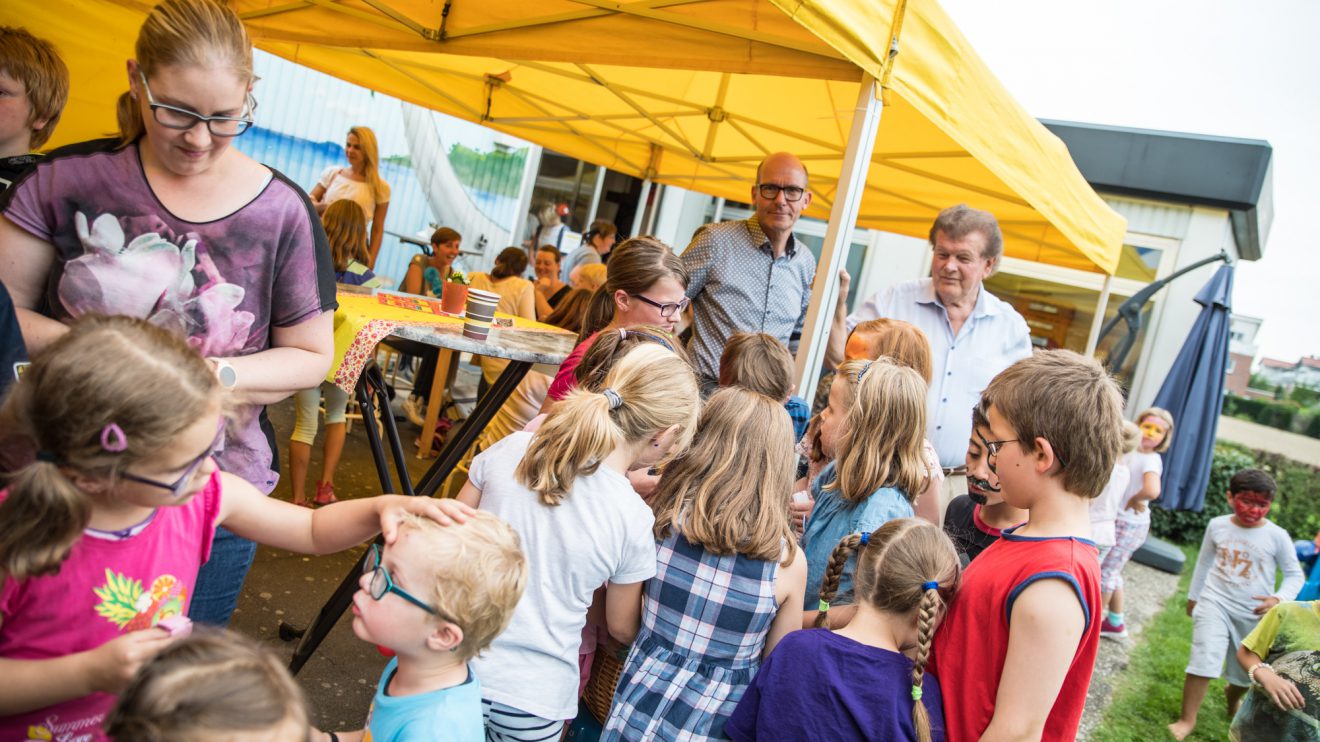 Rüdiger Mittmann und Alfons Schwegmann (hinten, von links) verteilen Süßigkeiten an die Kinder. Foto: Thomas Remme