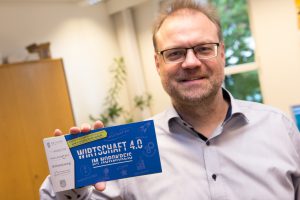 Wallenhorsts Wirtschaftsförderer Frank Jansing präsentiert den Flyer „Wirtschaft 4.0 im Nordkreis“. Foto: André Thöle
