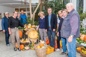 Die Mitglieder des Seniorenbeirats und weitere fleißige Helfer im Jahr 2017 im Foyer des Rathauses vor ihrem „Herbstbild“. Bürgermeister Otto Steinkamp (4. von rechts) besuchte sie beim Aufbau. Archivfoto: Thomas Remme