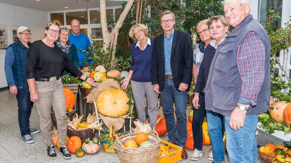 Die Mitglieder des Seniorenbeirats und weitere fleißige Helfer im Jahr 2017 im Foyer des Rathauses vor ihrem „Herbstbild“. Bürgermeister Otto Steinkamp (4. von rechts) besuchte sie beim Aufbau. Archivfoto: Thomas Remme