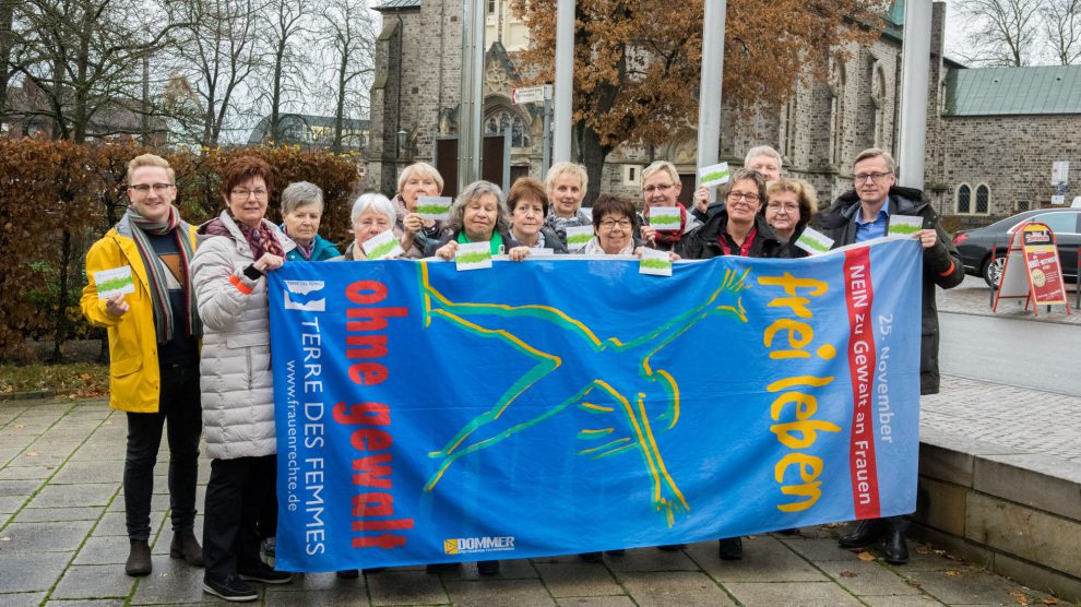 Ratsmitglieder und Vereinsvertreterinnen zeigen gemeinsam mit Bürgermeister Otto Steinkamp (rechts) und Kornelia Böert (4. von rechts) Flagge gegen Gewalt an Frauen. Foto: André Thöle