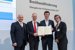 Schnelles Internet für das Osnabrücker Land: Einen Förderbescheid über weitere 15 Millionen Euro überreichte in Berlin Staatssekretär Rainer Bomba (von links) an Landrat Michael Lübbersmann, André Berghegger (MdB, CDU) und Frank Otte (Stadt Osnabrück). Foto: Bundesministerium für Verkehr und digitale Infrastruktur