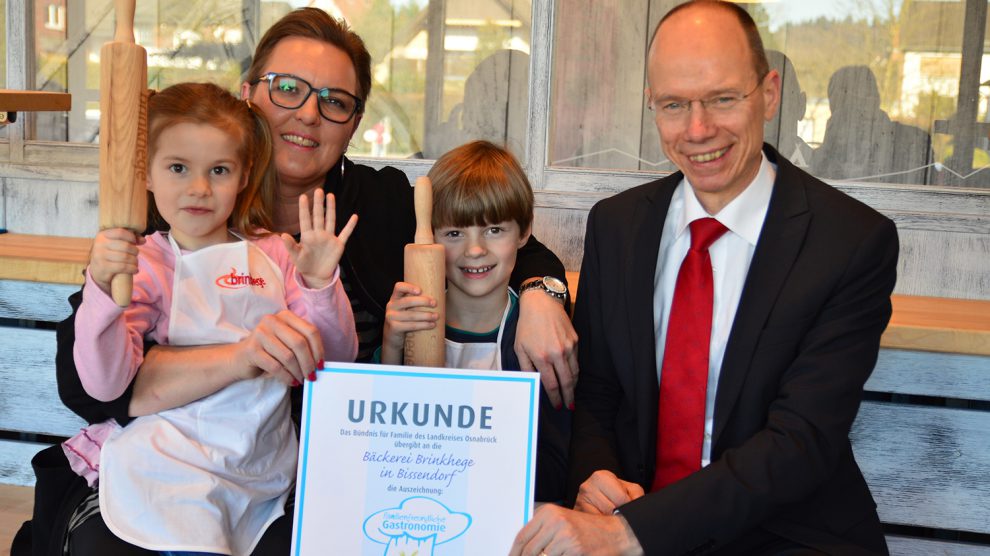 In der Bäckerei Brinkhege können sich Kinder auch als Nachwuchsbäcker versuchen, so wie hier Alyssa Lucia (5) und Fynn-Luca (7). Landrat Michael Lübbersmann überreichte Geschäftsführerin Heike Brinkhege das Zertifikat "Familienfreundliche Gastronomie". Foto: Landkreis Osnabrück/Henning Müller-Detert