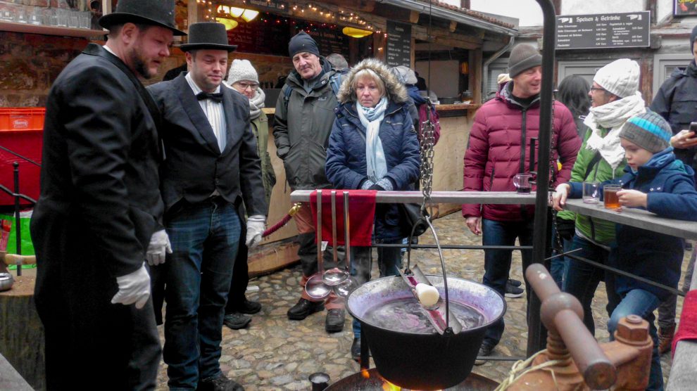 In der „Adventsstadt Quedlinburg“ bereiten die Gastgeber des Hofes „Pfeiffer mit drei f“ Feuerzangenbowle zu. Foto: Ursula Thöle