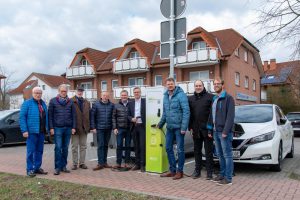 Bürgermeister Otto Steinkamp (4. von rechts), Björn Fütz (2. von rechts) und Stefan Sprenger (rechts) nehmen die E-Ladesäule gemeinsam mit Vertretern der Ratsfraktionen in Betrieb. Foto: Gemeinde Wallenhorst / André Thöle