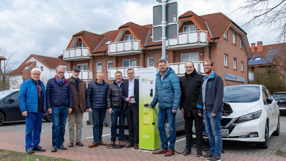 Bürgermeister Otto Steinkamp (4. von rechts), Björn Fütz (2. von rechts) und Stefan Sprenger (rechts) nehmen die E-Ladesäule gemeinsam mit Vertretern der Ratsfraktionen in Betrieb. Foto: Gemeinde Wallenhorst / André Thöle