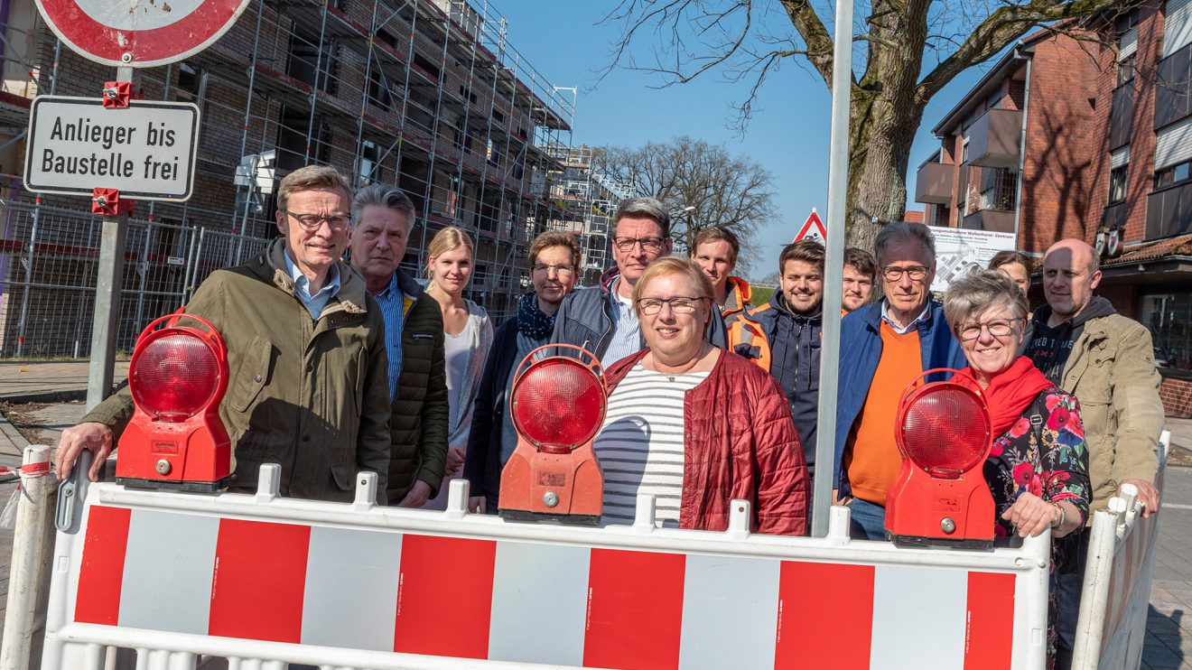 Ortstermin zum Baubeginn mit Bürgermeister Otto Steinkamp (links), Vertretern von Rat und Verwaltung, Planungsbüro, Sanierungsträger und Bauunternehmen. Links im Hintergrund der wachsende Gebäudekomplex „Wallenhorst 21“. Foto: Thomas Remme / Gemeinde Wallenhorst