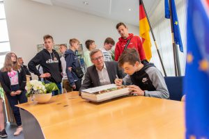 Die Jugendlichen aus Olsztyn tragen sich im Beisein von Bürgermeister Otto Steinkamp ins Goldene Buch der Gemeinde Wallenhorst ein. Foto: Gemeinde Wallenhorst / André Thöle