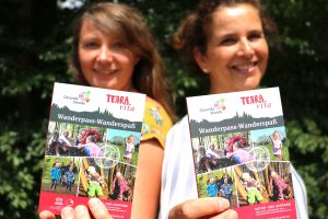 Melanie Schnieders (links) vom Natur- und Geopark TERRA.vita und Silke Tegeder-Perwas von der Gesunden Stunde präsentieren den neuen Wanderführer. Foto: Landkreis Osnabrück/Tobias Fischer