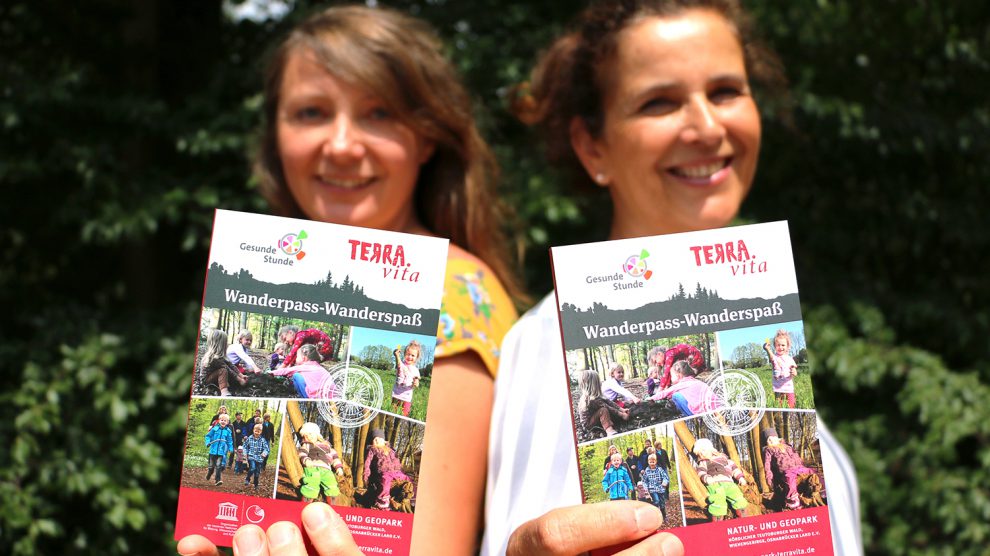 Melanie Schnieders (links) vom Natur- und Geopark TERRA.vita und Silke Tegeder-Perwas von der Gesunden Stunde präsentieren den neuen Wanderführer. Foto: Landkreis Osnabrück/Tobias Fischer