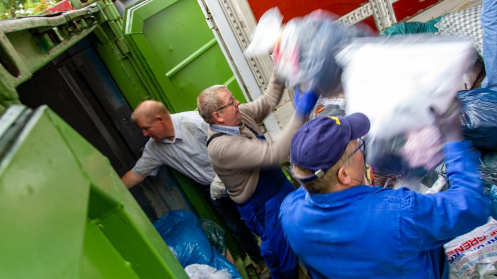 Aktive der Kolpingsfamilie Hollage verladen die gesammelten Altkleider in einen Lkw. Foto: André Thöle