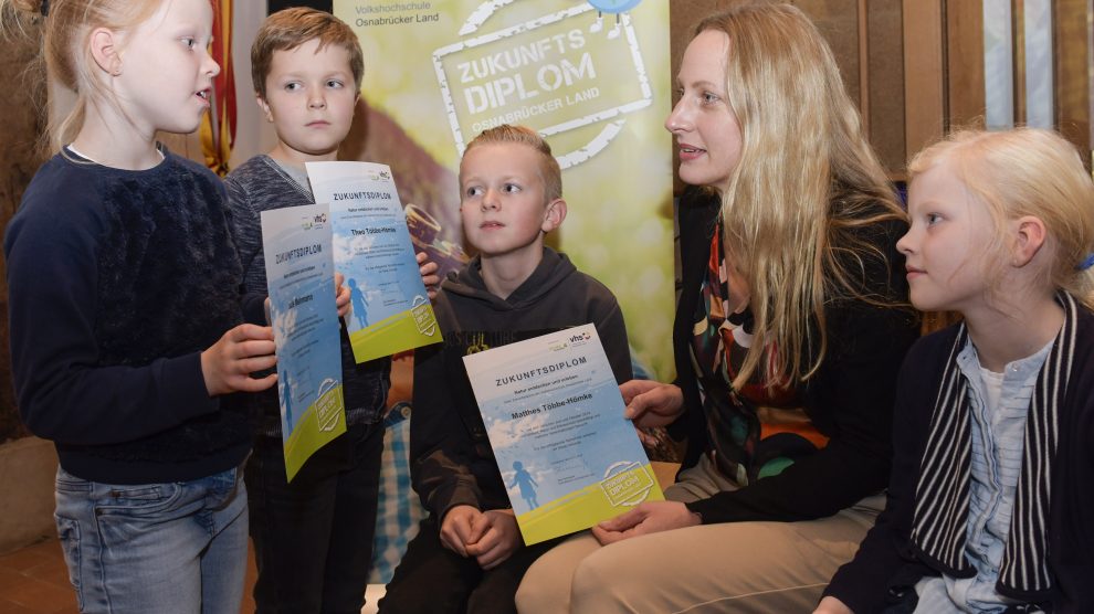 Präsentieren Landrätin Anna Kebschull (Mitte) stolz ihr Zukunftsdiplom: Jule Mehmann, Theo und Matthes Többe-Hömke und Mia Mehmann (v.l.n.r.). Foto: vhs Osnabrücker Land / Hermann Pentermann