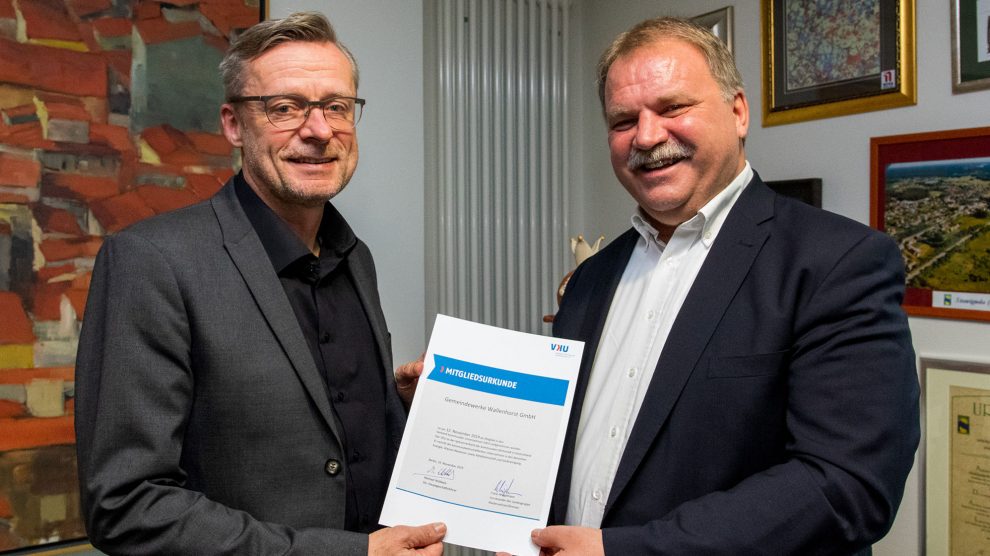 Dr. Reinhold Kassing (rechts) überreicht Bürgermeister Otto Steinkamp die VKU-Mitgliedsurkunde. Foto: Gemeinde Wallenhorst / André Thöle