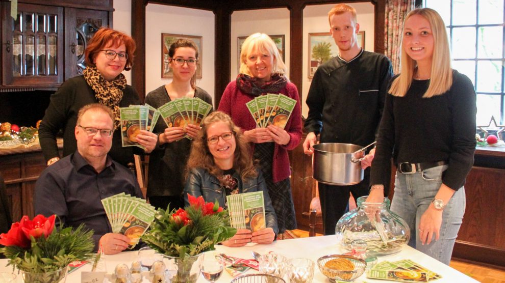 Die Tourismusfachleute der VarusRegion ziehen die Gewinner der Genussgutscheine im Landgasthaus Gieseke Asshorn: Frank Jansing, Christiane Wagner, Luisa Korte, Maike Schlichting, Anette Lange (von links) sowie Elisa Holtkamp (rechts). Foto: Gemeinde Bad Essen