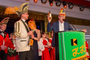 Bürgermeister Otto Steinkamp überreicht Prinz Thomas I. neben dem Rathausschlüssel auch eine Flasche „851“. Foto: Dennis Flegel / Kolpingsfamilie Hollage