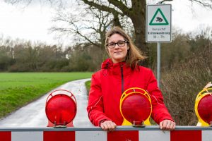 Zum Schutz von Kröten, Fröschen und Molchen werden im Außenbereich einige Straßen nachts gesperrt, wie Wallenhorsts Umweltbeauftragte Isabella Draber zeigt. Foto: André Thöle / Gemeinde Wallenhorst