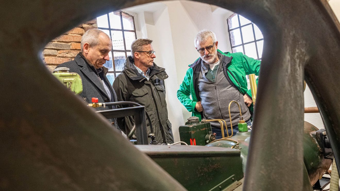 Franz Josef Albers (rechts) erläutert den Herforder Motor. Foto: Thomas Remme / Gemeinde Wallenhorst