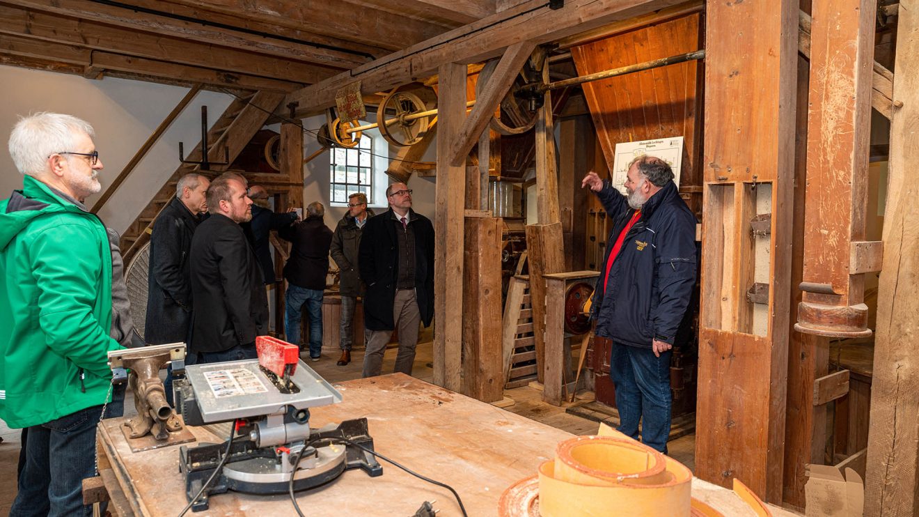 Ansgar Vennemann (rechts) erklärt die Funktionsweise der Motormühle. Foto: Thomas Remme / Gemeinde Wallenhorst