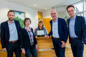 Bieten mit dem neuen Drucker den Fahrscheinkauf weiterhin im Wallenhorster Rathaus an (von links): Stephan Reich (Weser-Ems Bus), Verwaltungsmitarbeiterinnen Veronika Hamacher und Claudia Buttgereit, Rüdiger Mittmann sowie Jörg Schneider. Foto: Gemeinde Wallenhorst / André Thöle