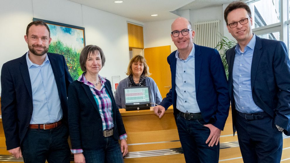 Bieten mit dem neuen Drucker den Fahrscheinkauf weiterhin im Wallenhorster Rathaus an (von links): Stephan Reich (Weser-Ems Bus), Verwaltungsmitarbeiterinnen Veronika Hamacher und Claudia Buttgereit, Rüdiger Mittmann sowie Jörg Schneider. Foto: Gemeinde Wallenhorst / André Thöle