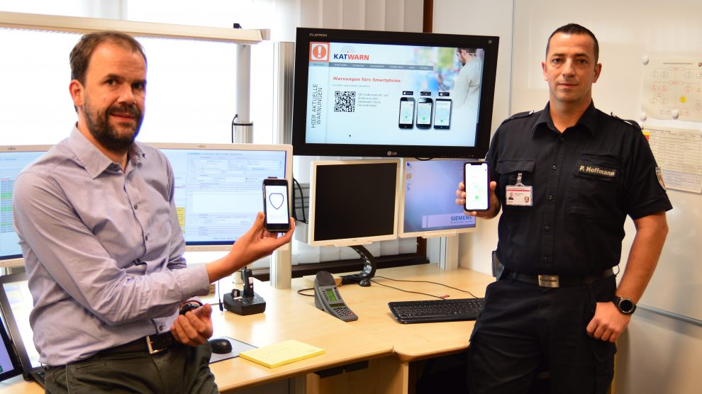 Fachdienstleiter Volker Trunt, Vorstand der Leitstelle im Kreishaus Osnabrück (links), und Peter Hoffmann (Projektverantwortlicher KatWarn) präsentieren die App KatWarn. Foto: Landkreis Osnabrück/Henning Müller-Detert