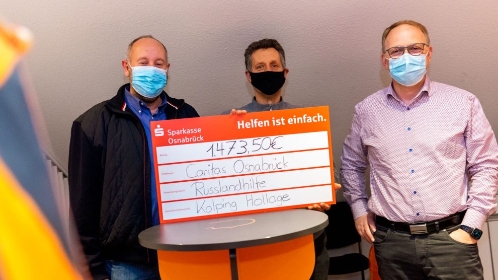 Burkhard Böwer und Heiner Placke (rechts) überreichen einen symbolischen Scheck über den Spendenbetrag an Caritas-Referent Ottmar Steffan (Mitte). Foto: André Thöle / Kolpingsfamilie Hollage