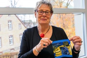 Wallenhorsts Gleichstellungsbeauftragte Kornelia Böert mit einem Brillenputztuch, das als Werbegeschenk zum Aktionstag über die Apotheken verteilt wird. Foto: André Thöle / Gemeinde Wallenhorst