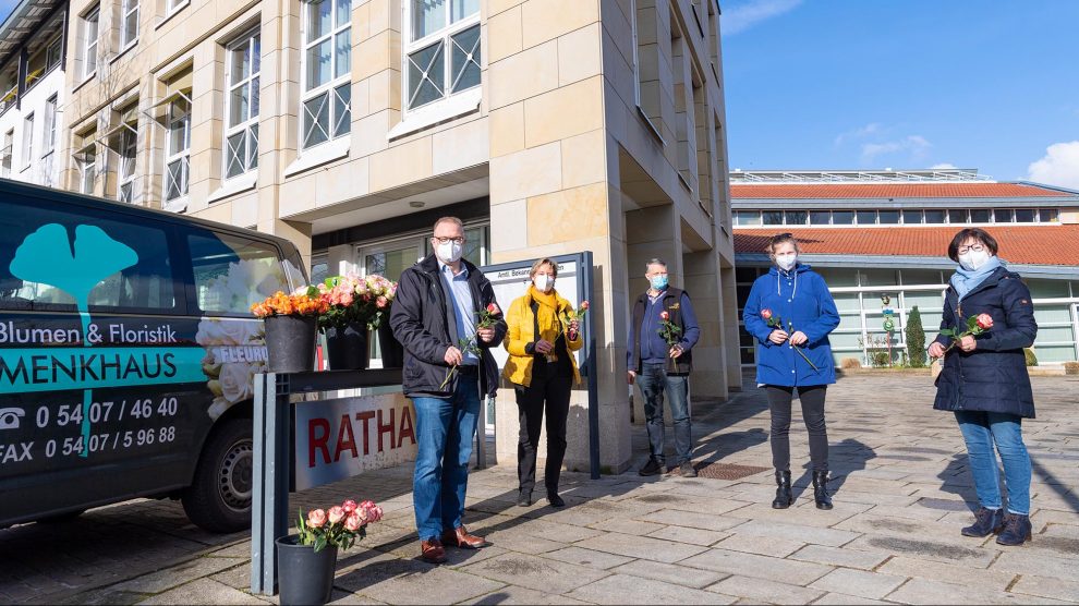 An Frank Jansing und Kornelia Böert (von links) liefert Udo Hörnschemeyer von Blumen & Floristik Menkhaus 300 Rosen, die auch von Sofie Krümberg und Angelika Bayer (beide Arbeitsgruppe Fairtrade) an die Wallenhorster Pflegeeinrichtungen verteilt werden. Foto: Michael Helweg / Clean Fotostudio GmbH