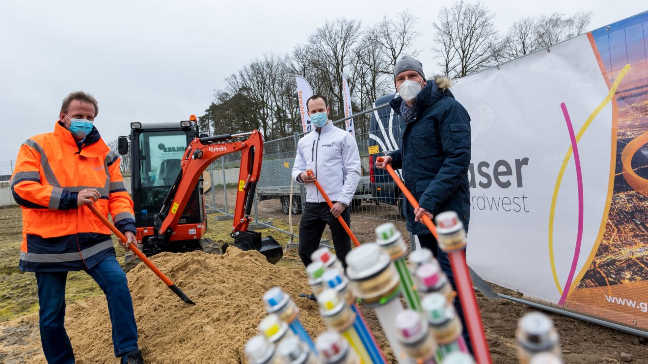 René Winter (Geschäftsführer des Bauunternehmens K&R Eilers), Oliver Prostak und Rüdiger Mittmann (von links) greifen zum Beginn des Netzausbaus symbolisch zum Spaten. Foto: André Thöle / Gemeinde Wallenhorst