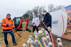 René Winter (Geschäftsführer des Bauunternehmens K&R Eilers), Oliver Prostak und Rüdiger Mittmann (von links) greifen zum Beginn des Netzausbaus symbolisch zum Spaten. Foto: André Thöle / Gemeinde Wallenhorst