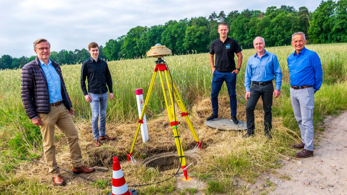 Bürgermeister Otto Steinkamp, Werner Pape (Landesamt Geoinformation Niedersachsen), Christian Meyer (Landesamt Geoinformation Bremen), André Sieland und Dr. Jens Riecken (von links) an der Messstelle in Wallenhorst. Foto: André Thöle / Gemeinde Wallenhorst