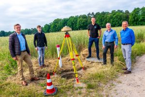 Bürgermeister Otto Steinkamp, Werner Pape (Landesamt Geoinformation Niedersachsen), Christian Meyer (Landesamt Geoinformation Bremen), André Sieland und Dr. Jens Riecken (von links) an der Messstelle in Wallenhorst. Foto: André Thöle / Gemeinde Wallenhorst