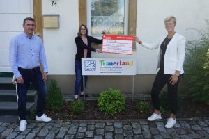 Abteilungsvorsitzender Rainer Brune (l.) und Ehrenamtsmanagerin Jennifer Juber (r.) übergeben den Spendenscheck an Trauerland-Leiterin Marion Gövert. Foto: Marcella Marques