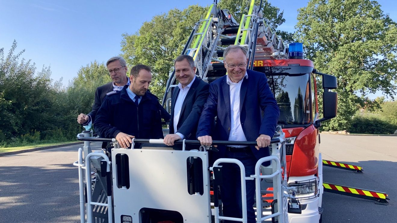 Gemeindebrandmeister Timo Wischmeier-Raffelt (2. von links) demonstriert Bürgermeister Otto Steinkamp (links), Guido Pott (2. von rechts) und Ministerpräsident Stephan Weil den Funktionsumfang des neuen Drehleiter-Fahrzeugs. Foto: Hendrik Chmiel / Büro Guido Pott