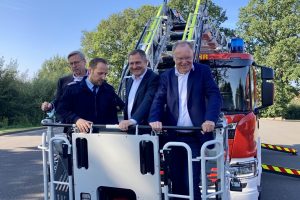 Gemeindebrandmeister Timo Wischmeier-Raffelt (2. von links) demonstriert Bürgermeister Otto Steinkamp (links), Guido Pott (2. von rechts) und Ministerpräsident Stephan Weil den Funktionsumfang des neuen Drehleiter-Fahrzeugs. Foto: Hendrik Chmiel / Büro Guido Pott