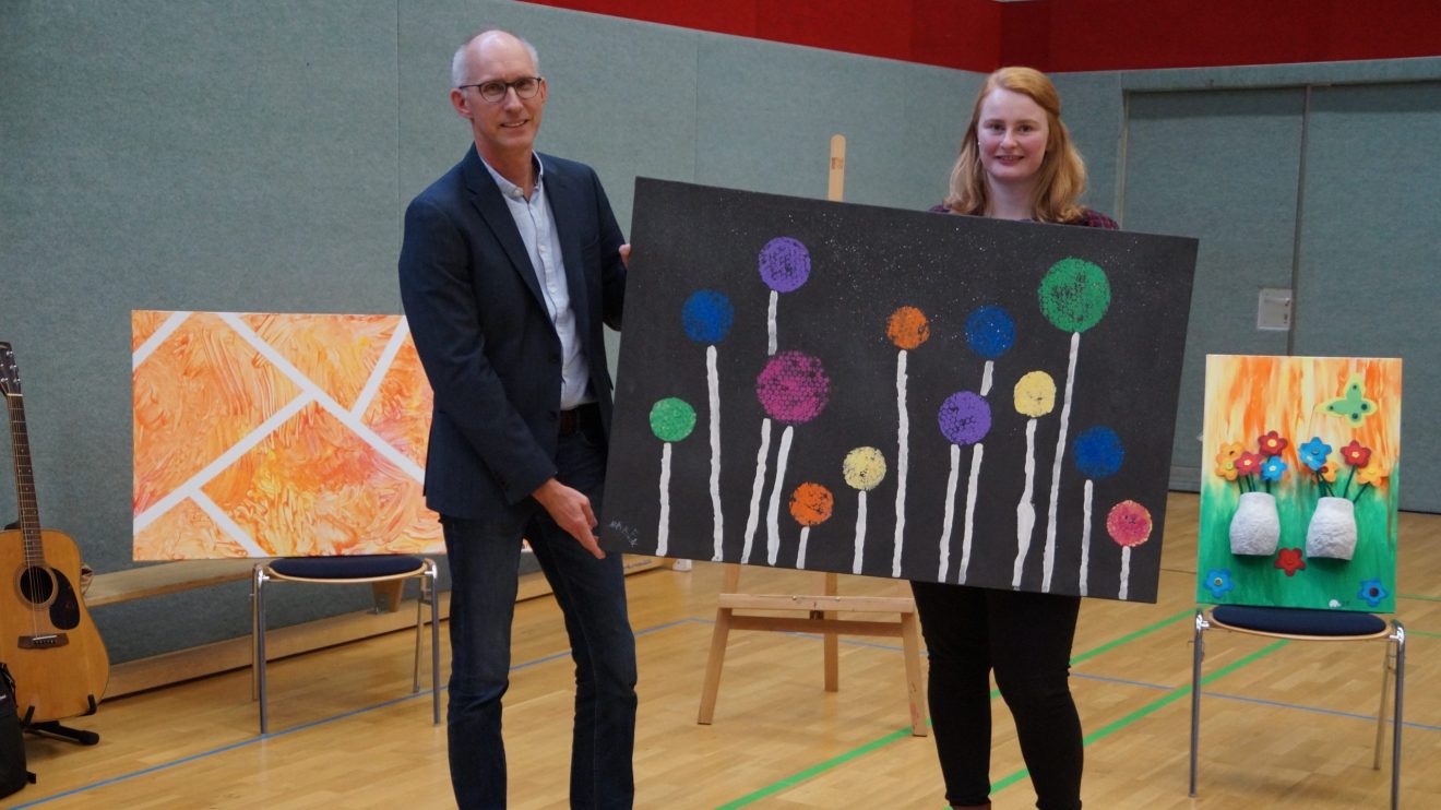 Ersteigerte eines von elf Kunstwerken: Pastor Martin Steinke mit der Leiterin der Andreas-Kita, Mareike Teepe. Foto: Andreas-Kita / Jutta Stein