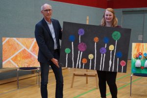 Ersteigerte eines von elf Kunstwerken: Pastor Martin Steinke mit der Leiterin der Andreas-Kita, Mareike Teepe. Foto: Andreas-Kita / Jutta Stein