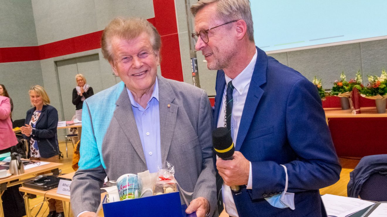 Unter stehenden Ovationen verabschiedet Bürgermeister Otto Steinkamp (rechts) Alfons Schwegmann, der sich 49 Jahre lang im Rat engagierte, 25 Jahre davon als stellvertretender Bürgermeister. Foto: André Thöle / Gemeinde Wallenhorst