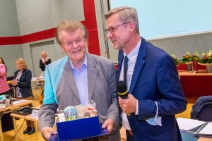 Unter stehenden Ovationen verabschiedet Bürgermeister Otto Steinkamp (rechts) Alfons Schwegmann, der sich 49 Jahre lang im Rat engagierte, 25 Jahre davon als stellvertretender Bürgermeister. Foto: André Thöle / Gemeinde Wallenhorst