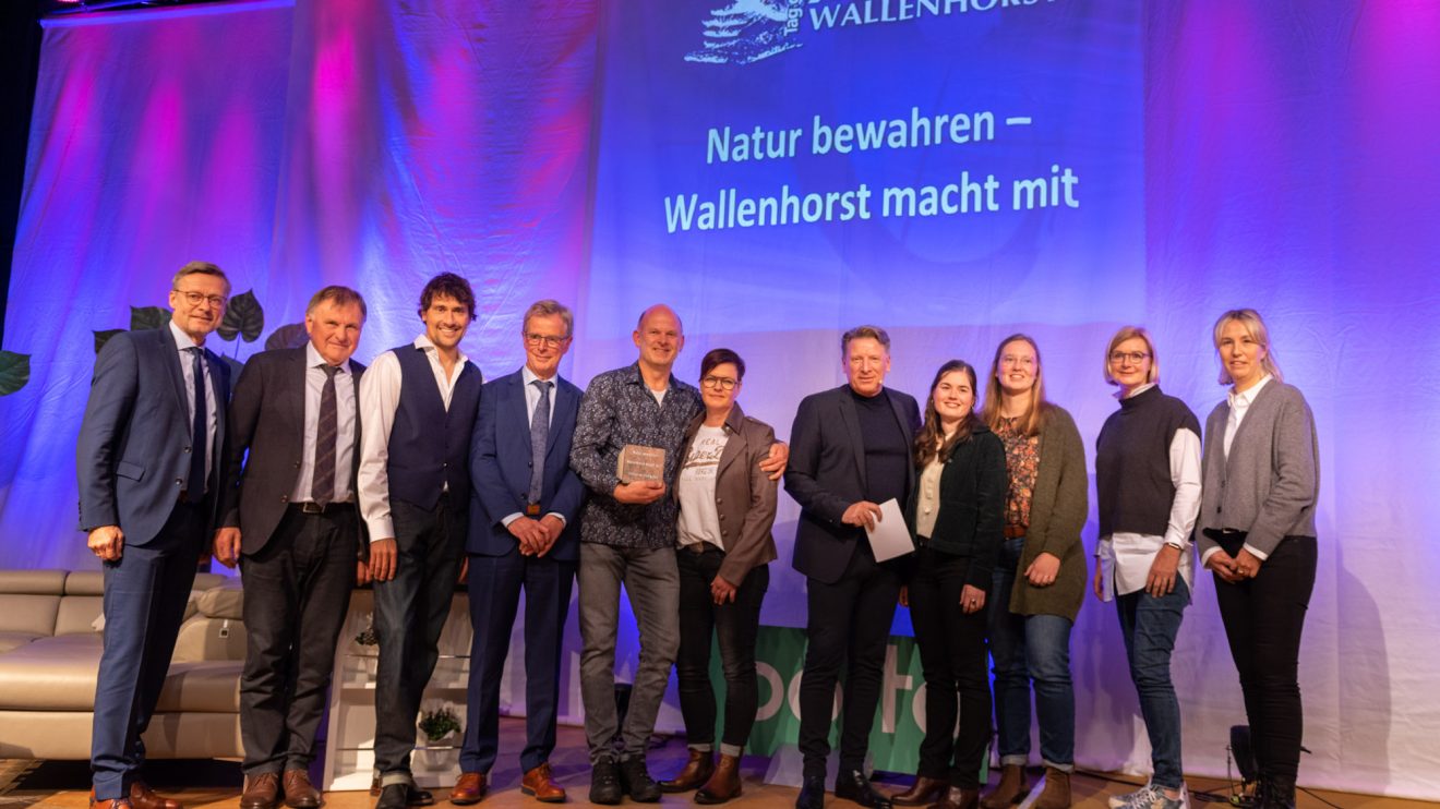 Gruppenbild zur Preisverleihung: Christian und Anja Voßgröne (Mitte) umrahmt von Ehrengästen und den Lehrerinnen der Erich-Kästner-Schule. Foto: André Thöle / Gemeinde Wallenhorst