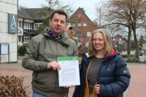 Alexander Strehl und Lilian-Ruth Sasse mit ihrem Antrag für Luftfilter vor der Hollager Erich-Kästner-Schule. Foto: Lilian-Ruth Sasse