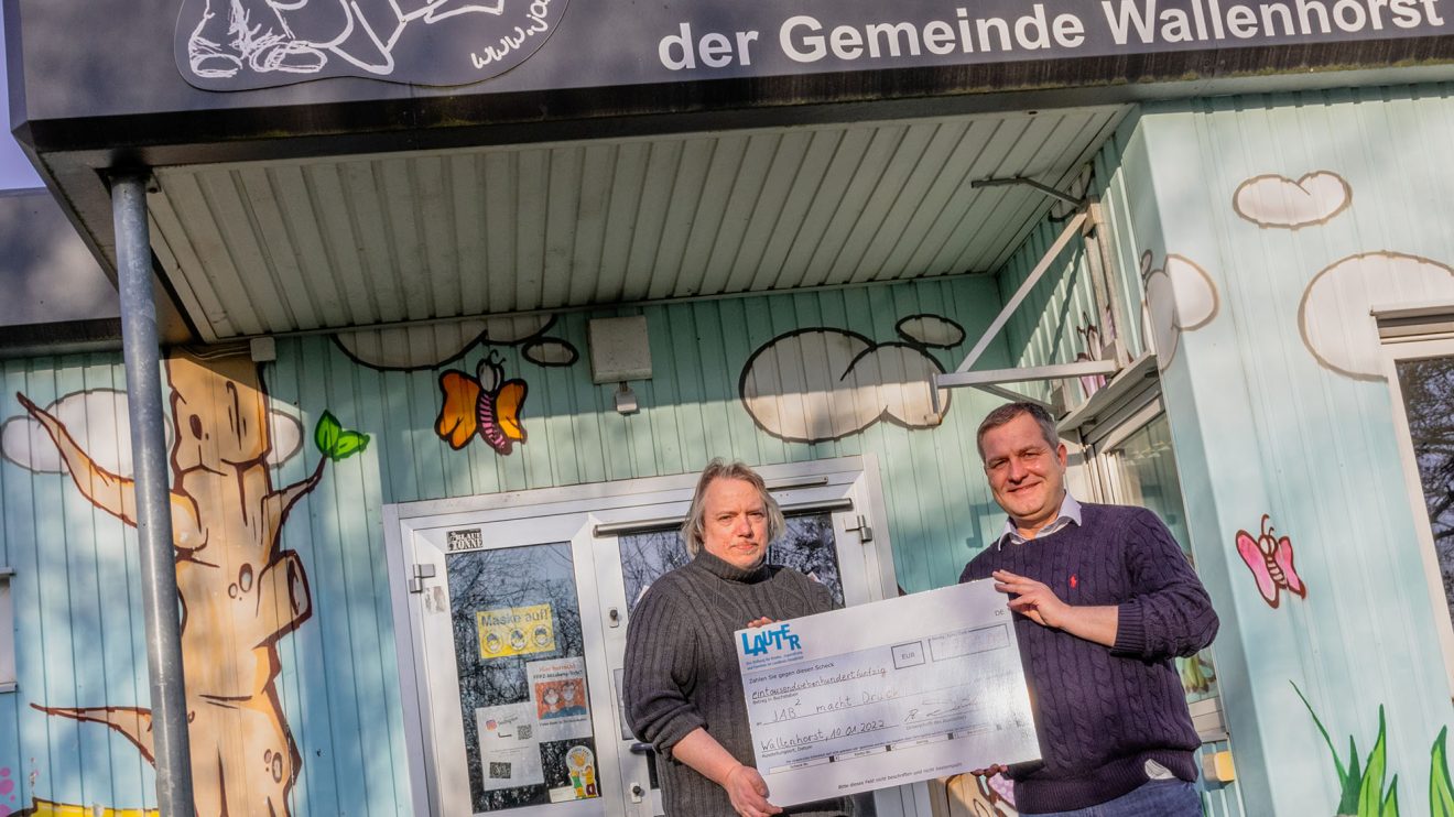 Guido Pott (rechts) überreicht Jürgen Abeln einen symbolischen Scheck über die Fördersumme von 1.750 Euro. Foto: André Thöle / Gemeinde Wallenhorst