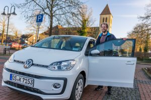 Stefan Sprenger mit dem VW up!, der ab sofort allen Stadtteilauto-Kundinnen und Kunden am Josefsplatz in Hollage zur Verfügung steht. Foto: André Thöle / Gemeinde Wallenhorst