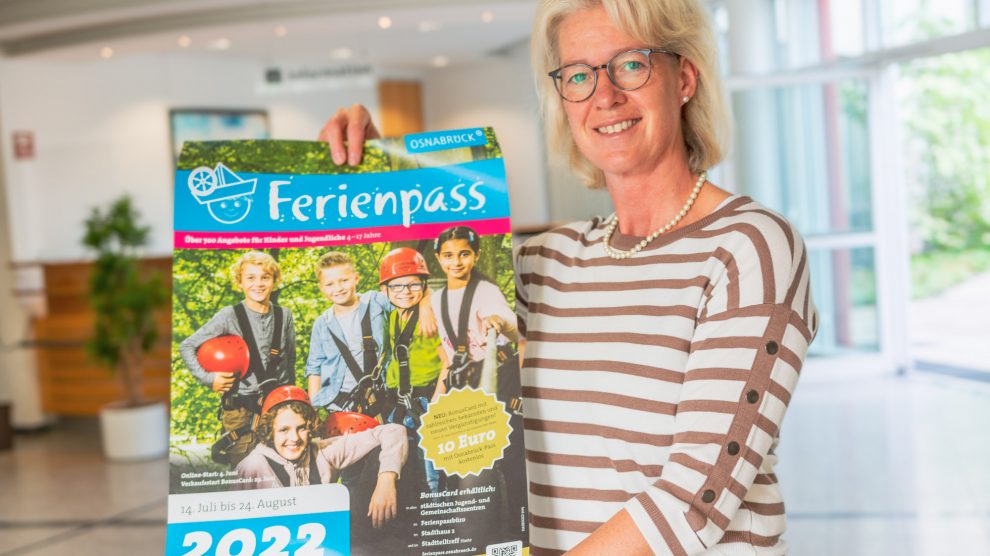 Christina Middendorp vom Familienservicebüro mit dem Plakat zum Osnabrücker Ferienpass, den auch Wallenhorster Kinder in den Sommerferien nutzen können. Foto: André Thöle / Gemeinde Wallenhorst