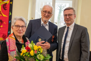 Bürgermeister Otto Steinkamp gratuliert Erich Goer und überreicht dessen Frau Lilo einen Blumenstrauß. Foto: André Thöle / Gemeinde Wallenhorst