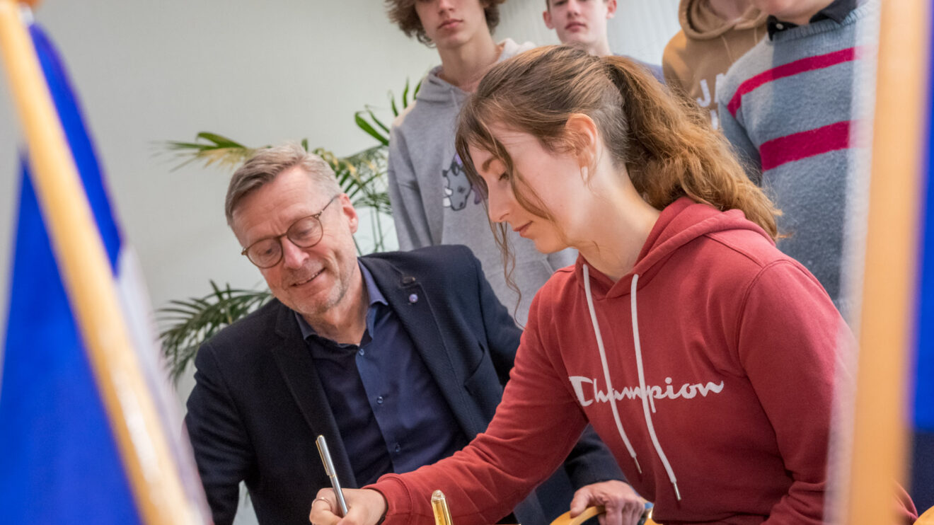 Französische und deutsche Schülerinnen und Schüler sowie die begleitenden Lehrerinnen tragen sich ins Goldene Buch ein. Foto: André Thöle